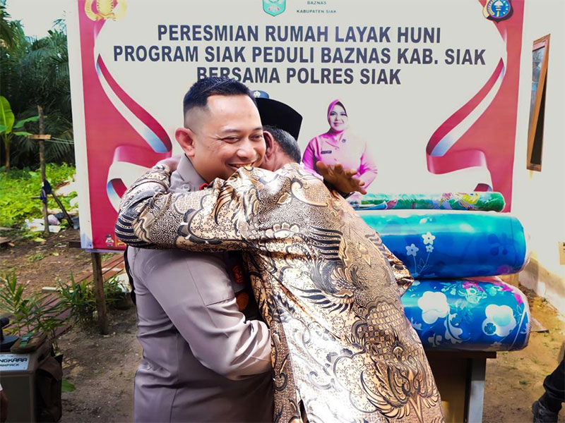 Kapolres Siak AKBP Asep Sujarwadi SIK MSi dipeluk Supadi saat menerima rumah layak huni (RLH) di Kampung Buantan Besar, Kecamatan Siak, Rabu (10/1/2024).
