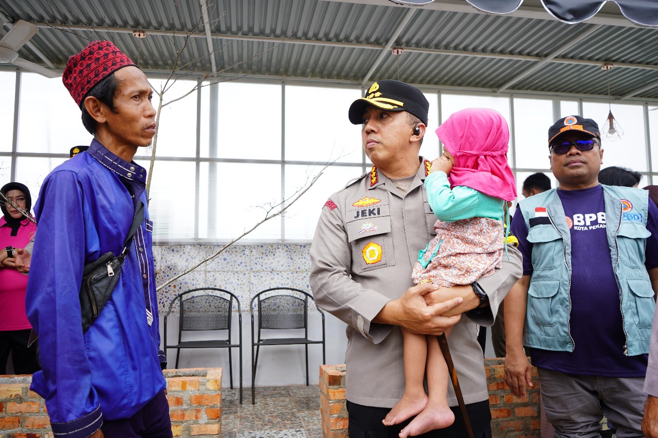 Kapolresta Pekanbaru Kombes Pol Jeki Rahmat Mustika menggendong balita yang mengalami gizi buruk, di Kecamatan Rumbai, Jumat (12/1/2024).