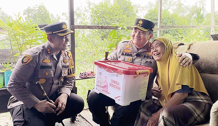 Kapolda Riau Irjen Pol Mohammad Iqbal (tengah) didampingi Kapolres Dumai AKBP Dhovan Oktavianton (kiri) foto bersama salah seorang warga Kecamatan Dumai Barat yang sakit keras, Siti Hajar.