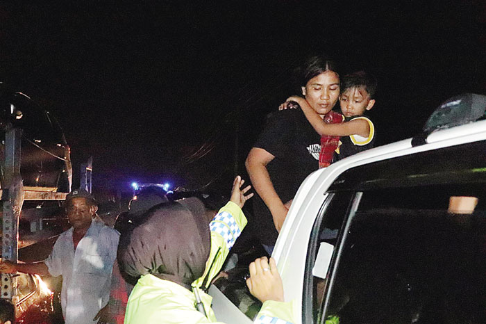 Personel Satlantas Polres Pelalawan bersama petugas gabungan membantu penumpang truk towing yang mogok terjebak banjir di Jalintim Km 83 Desa Kemang, Kecamatan Pangkalan Kuras, Pelalawan, (12/1/2024)