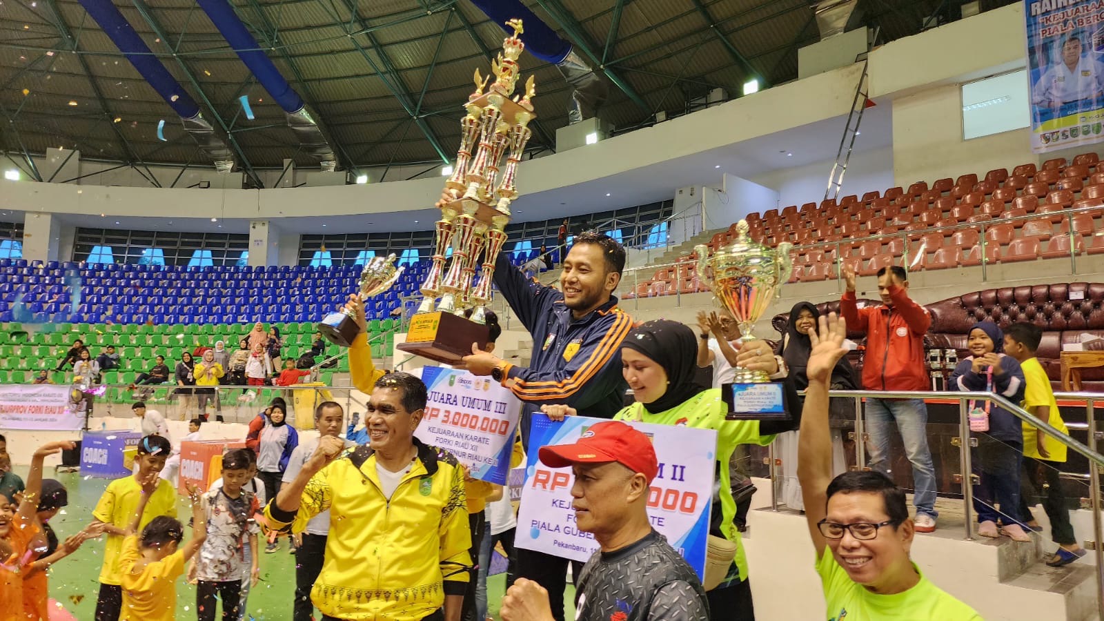 Ketua Forki Kota Pekanbaru Firmansyah LC mengangkat tropy juara umum Kejurprov Karate FORKI Riau XII 2024 usia diserahkan ketua Forki Riau Pariaman Ihwan (jaket kuning), Sabtu (13/1/2024).
