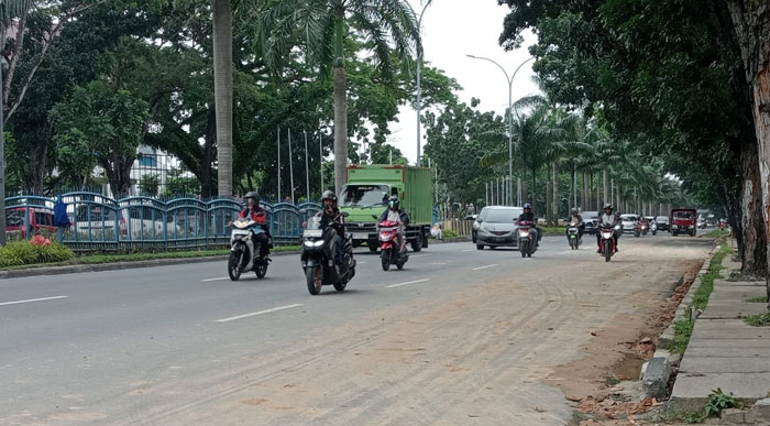 Pengendara melintas di dekat lokasi ceceran tanah timbun di Jalan Jenderal Sudirman, Ahad (14/1/2024).