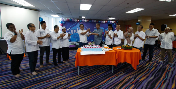 Komisaris Riau Pos Raznizal Syukur menyerahkan potongan kue HUT ke-33 Riau Pos kepada Direktur Utama Riau Pos Ahmad Dardiri