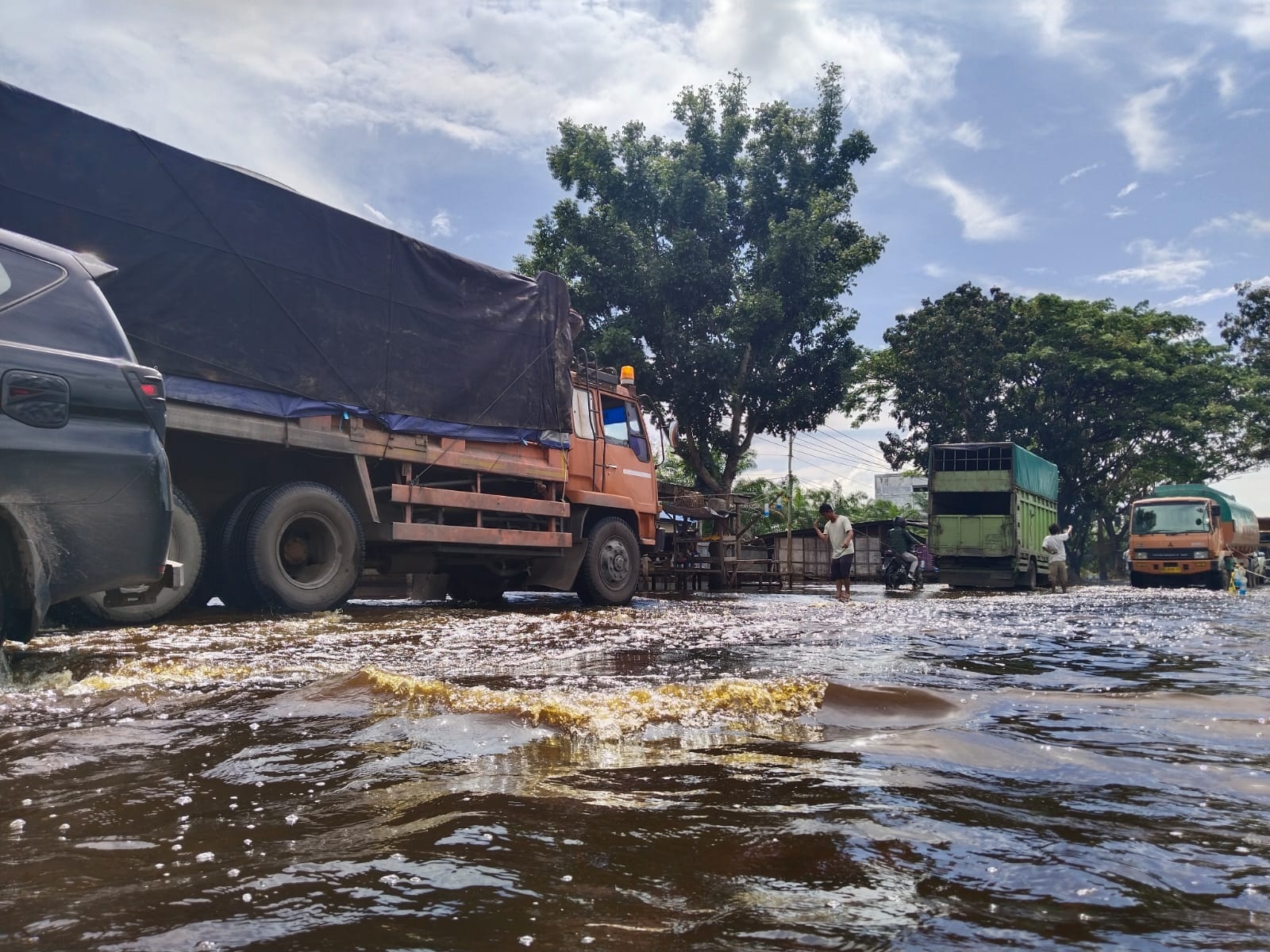 Truk melintas di jalan banjir Riau-Sumut tepatnya di Ujungtanjung, Kamis (18/2/2024).