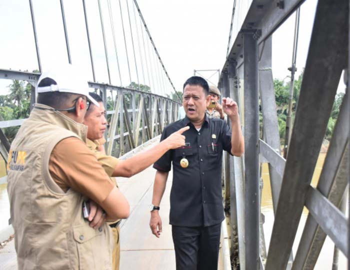 Pj Bupati Kampar Hambali SE MBA MH didampingi Kadis PUPR Afdal meninjau langsung kondisi jembatan gantung penyeberangan di Desa Gobah, Kecamatan Tambang, Kabupaten Kampar,