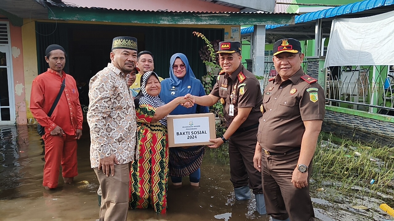 Kajari Pekanbaru Asep Sontani Sunarya, didampingi Wakajati Riau Hendrizal Husin menyerahkan bantuan banjir kepada warga Meranti Pandak, Jumat (19/1/2024).