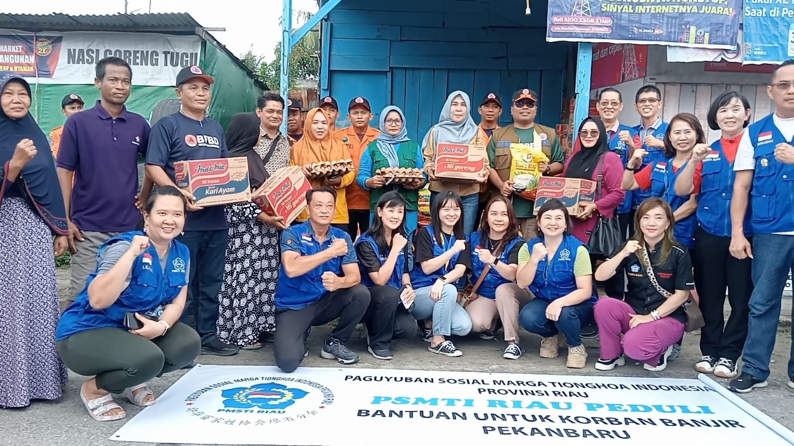 Humas PSMTI Riau KetTjing bersama pengurus lainnya dan Kalaksa BPBD Kota Pekanbaru Zarman Candra foto bersama warga terdampak banjir.