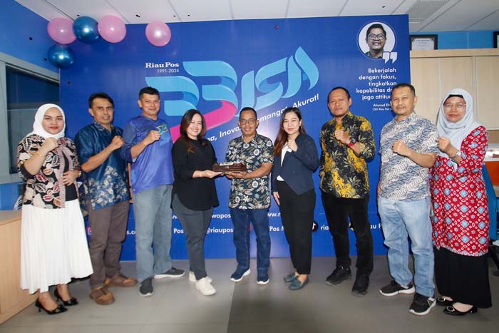 Direktur Riau Pos Asmawi Ibrahim menerima kue HUT ke-33 Riau Pos dari Novotel Pekanbaru yang diserahkan Corporate Communication Novotel Pekanbaru Meli dan Rila di ruang Redaksi Riau Pos
