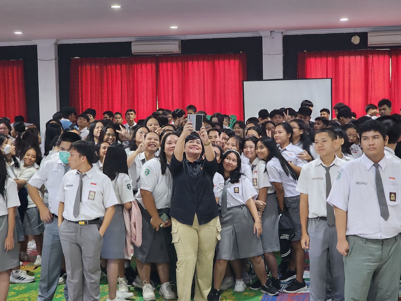 Petugas dari Ditresnarkoba Polda Riau berswafoto bersama ratusan siswa-siswi SMA Santa Maria Pekanbaru usai sosialisasi, Selasa (23/1/2024).