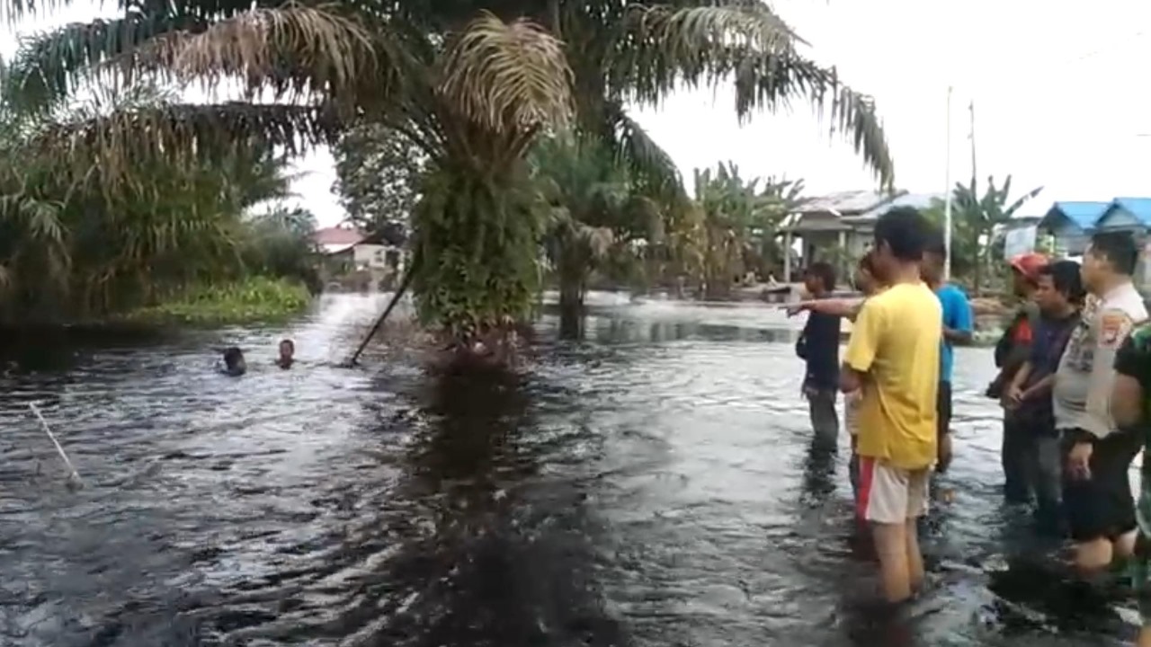 Warga bersama pihak kepolisian melihat lokasi tenggelamnya dua bocah SD yang ditemukan meninggal di aliran Sungai Kualo, Jalan Pulau Payung, Pangkalan Kerinci, , Selasa (23/1/2024).