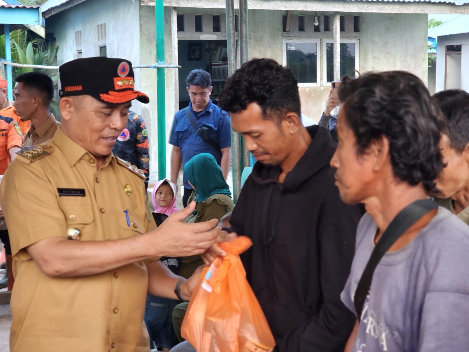 Pj Bupati Inhil H Herman, menyerahkan bantuan sembako bagi korban yang terdampak banjir di Tembilahan Hulu, Selasa (23/1/25).