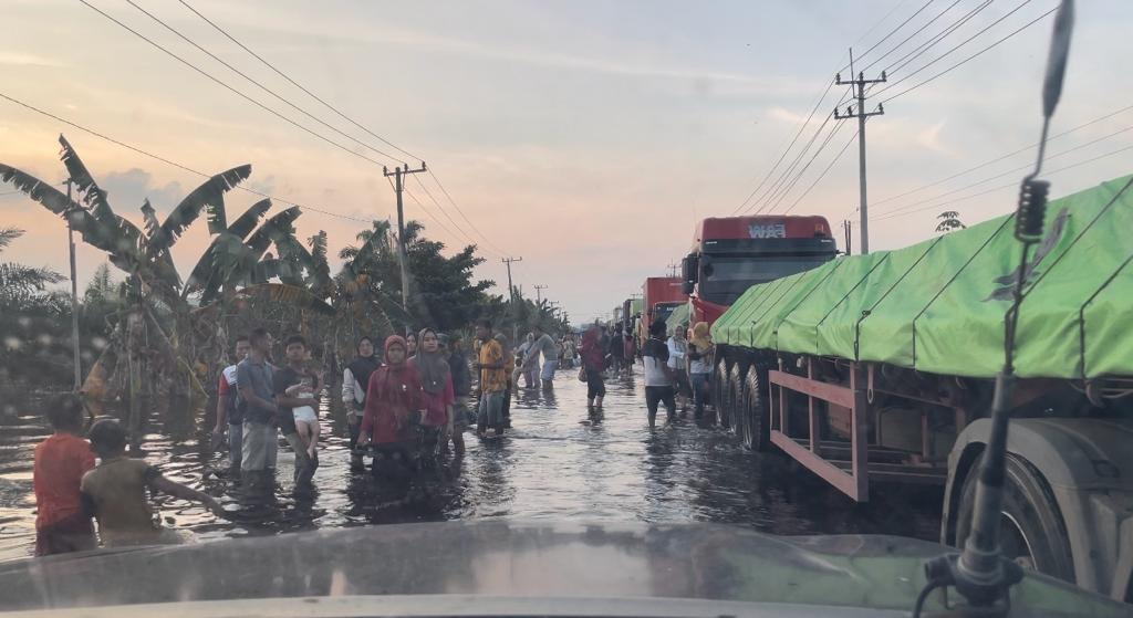 Antrean panjang kendaraan di Jalan Lintas Timur Kabupaten Pelalawan dampak masih belum surut totalnya banjir yang menggenangi KM 83 Desa Kemang Kecamatan Pangkalan Kuras, Rabu (24/1).