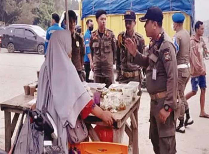 Kepala Satpol PP dan Damkar Tengku Junaidi MAp bersama personel menertibkan PKL yang menggunakan bahu Jalan Arbes Pangkalankerinci, beberapa waktu lalu.