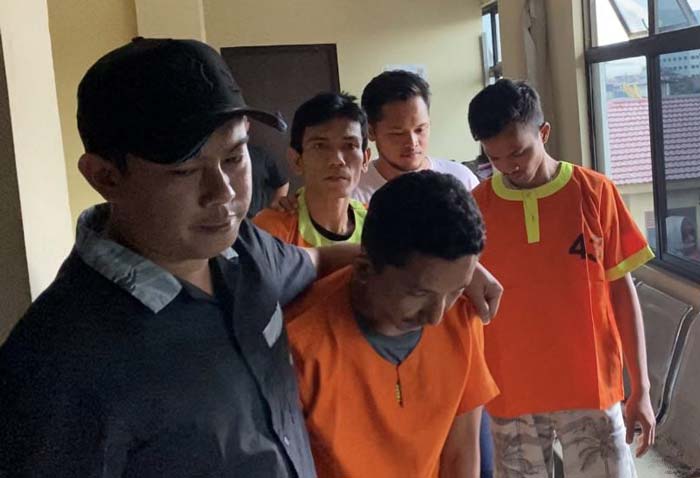 Kanit Jatanras Satreskrim Polresta Pekanbaru Iptu Renaldy Yudhistira (kiri) menggelandang tiga pencuri spesialis aki mobil ke tahanan Mapolresta Pekanbaru, Rabu (24/1/2024).