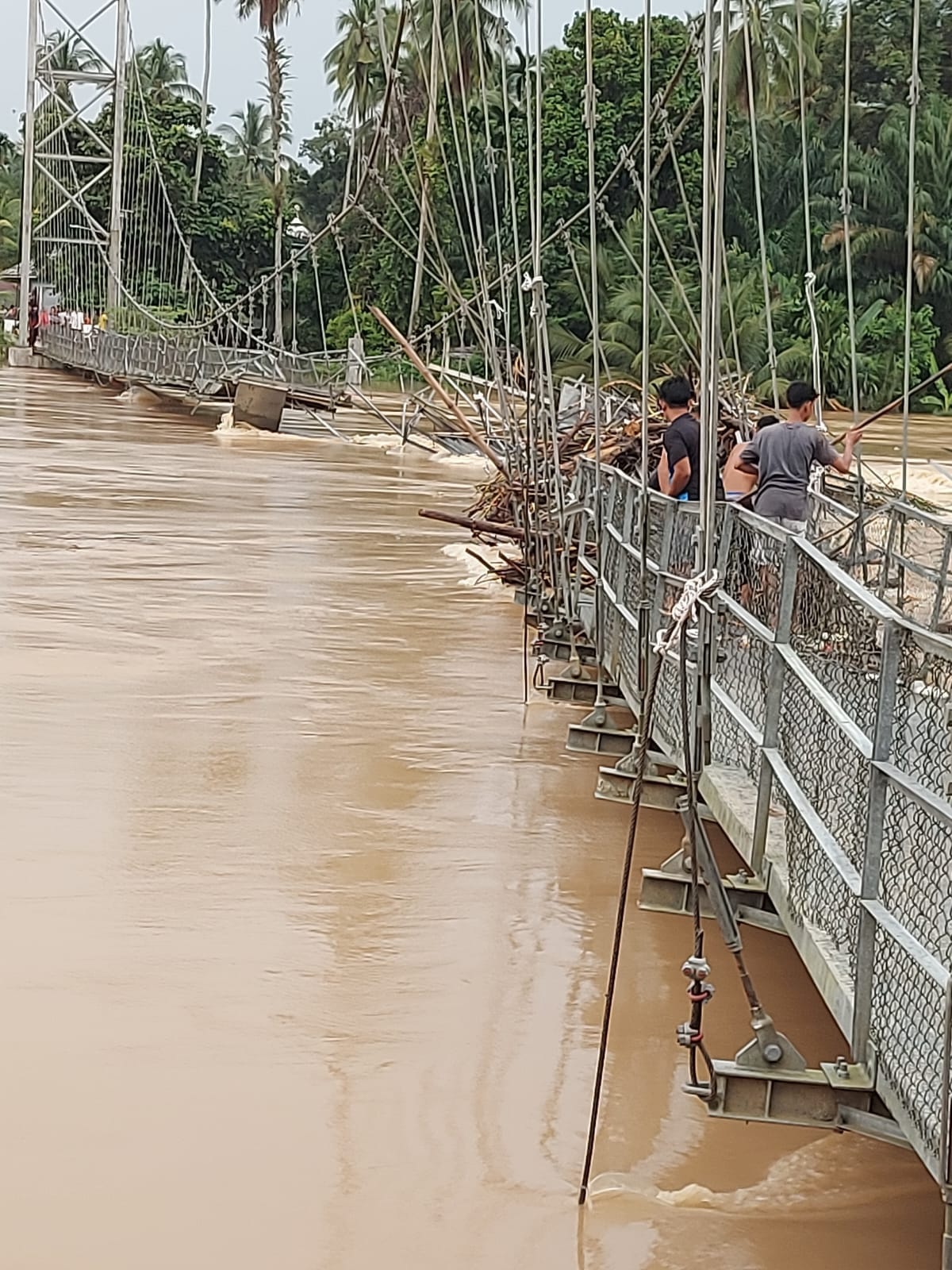 Jembatan Gantung Desa Bukit Kauman-Desa Pebaun Hilir yang rusak berat di hantam luapan sungai Kuantan.