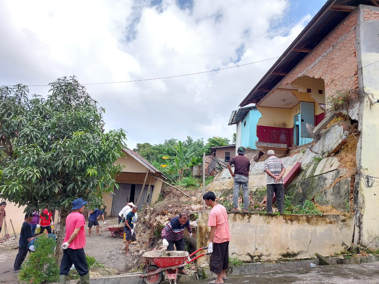Warga gotong royong di lokasi turap longsor yang menyababkan sebagian bangunan Masjib Babul Hasanah di Jalan Hasanah Indah, Harapanraya, Pekanbaru, Sabtu (27/1/2024).