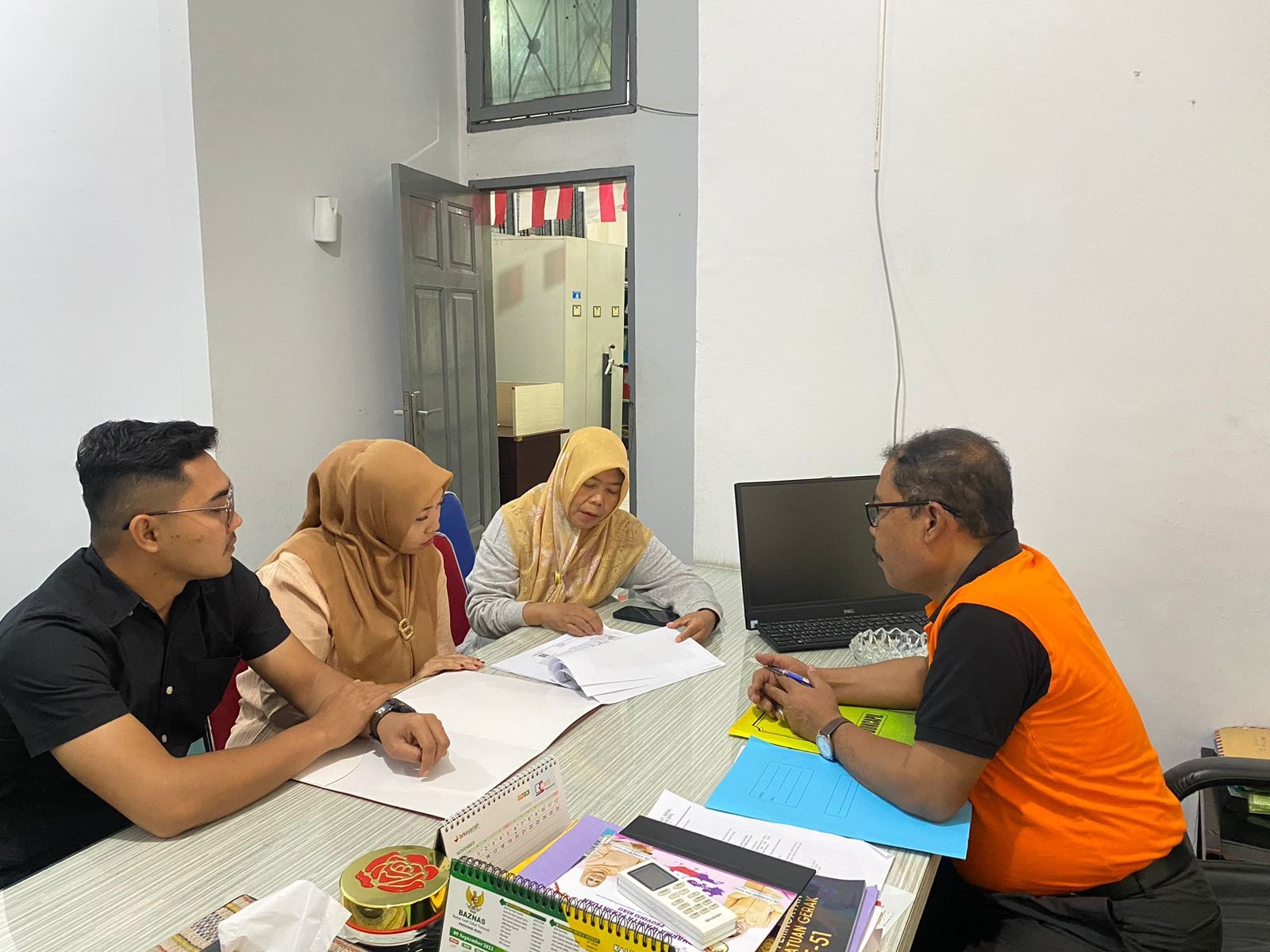 Petugas dari Dittahti Polda Riau saat berdiskusi dengan Sekretaris PMD Disdukcapil Provinsi Riau Aswan, Kamis (1/2/2024).