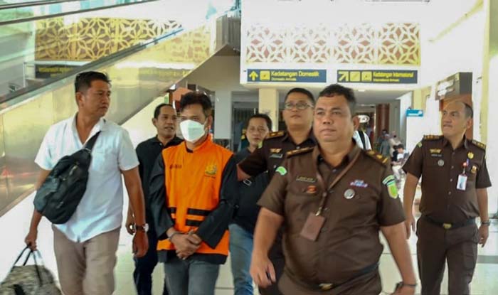 Tim Tabur Kejati Riau dan Tim Penyidik Pidsus Kejati Riau menggiring tersangka HM Fadhillah Akbar (rompi oren) di Bandara SSK II Pekanbaru, Rabu (31/1/2024).