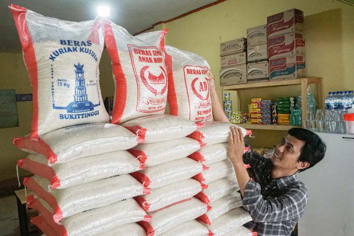 Seorang pedagang sedang menyusun karung beras di kedai miliknya, belum lama ini. Beras menjadi penyumbang inflasi di Riau di bulan Januari lalu.