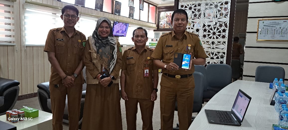 Sekretaris Daerah Kabupaten Inhu, Ir H Hendrizal MSi didampingi pegawai Disdukcapil, saat menunjukkan handphone usai melakukan aktivasi KTP digital, Kamis (5/2/2024).