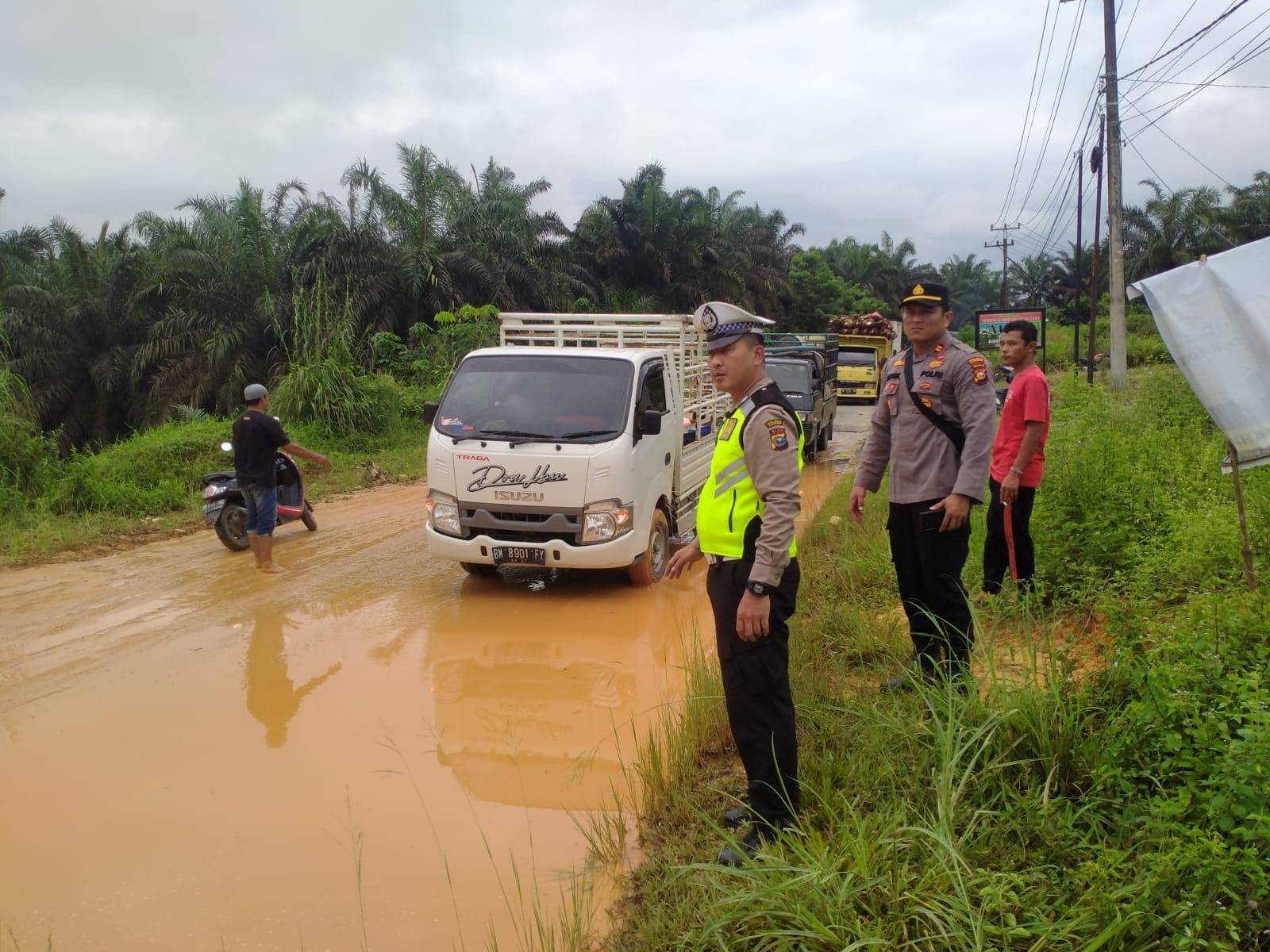 Kapolsek Bangkinang Barat, Iptu Rian Onel saat meninjau pengerjaan alat berat yang membersihkan material longsor, di Desa Silam, beberapa waktu lalu.
