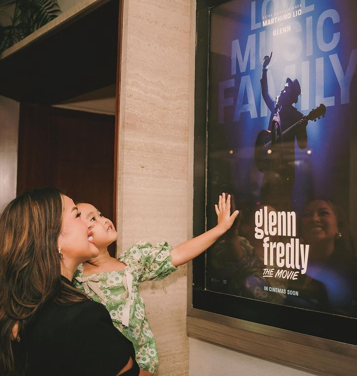 Mutia Ayu dan anaknya Gewa saat menatap poster Film Glenn Fredly.