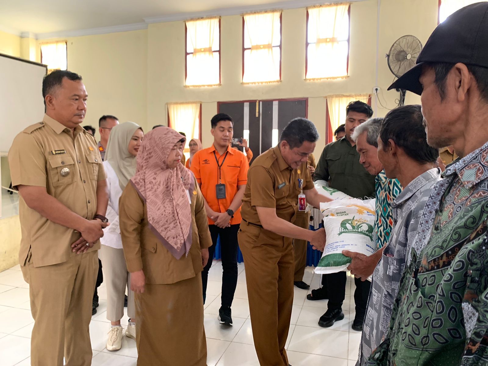 Asisten I Bidang Pemerintahan dan Kesra, H Syahrudin S.Sos MT didampingi Kepala DKP Inhu, Ir Hj Isnidar menyerahkan bantuan beras secara simbolis kepada perwakilan warga, Selasa (6/2/2024).