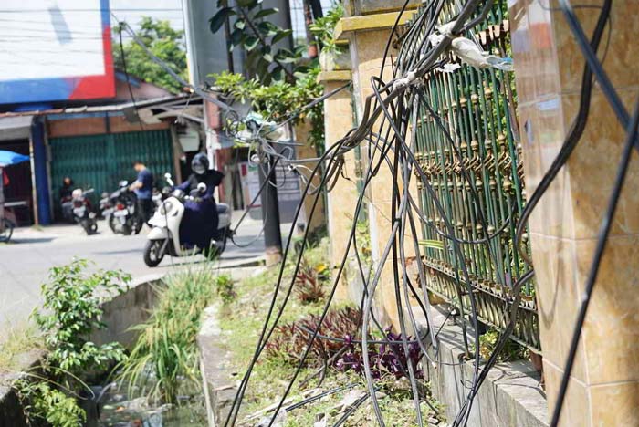 Kabel telekomunikasi menjuntai di Jalan Cempaka Pekanbaru, Kamis (1/2/2024). Kabel yang menjuntai ini sangat membahayakan bagi pengendara yang  melintas.