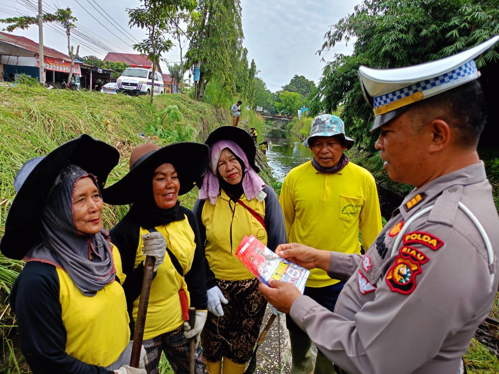 Personel Subdit Gakkum Ditlantas Polda Riau memberikan brosus imbauan keselamatan lalu lintas dan pesan Kamtibmas usai goro bersama petugas kebersihan di Kota Pekanbaru, Kamis (8/2/2024).