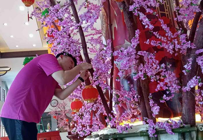 Salah seorang abdi vihara dan umat di  Maha Vihara dan Pusdiklat Bumi Suci Maitreya, Jalan Riau ujung, Pekanbaru mempersiapkan pohon harapan jelang datangnya Tahun Baru Imlek 2575/2024 Masehi
