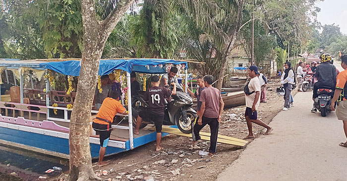 Pekerja kapal penyeberangan menurunkan sepeda motor di Penyeberangan Dusun Pulau Payung, Pangkalankerinci, Pelalawan, Jumat (9/2/2024).