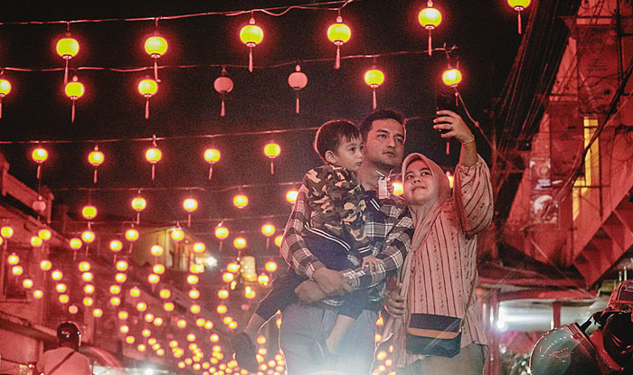 Masyarakat mengabadikan ratusan lampion jalan Karet, Pekanbaru untuk berswafoto, Kamis (8/2/2024) malam.