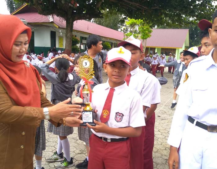 Ketua K3S Kecamatan Binawidya Raja Seatinis MPd saat menyerahkan piala kepada Tim Bolavoli SDN 130 Pekanbaru,  belum lama ini.