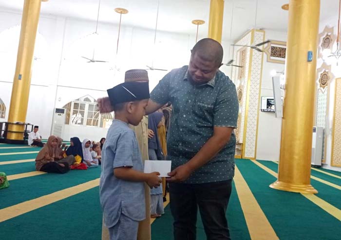 Ketua Umum Masjid Besar Arafah Duri Riki Rihardi menyerahkan santunan kepada anak yatim di lingkungan Masjid Arafah Duri, Sabtu (10/2/2024).