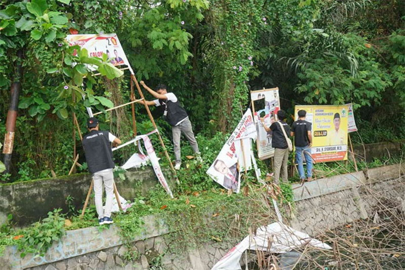 Petugas dari Bawaslu melakukan penertiban APK di Jalan Jenderal Sudirman Pekanbaru, Ahad (11/2/2024). Penertiban ini dilakukan karena telah memasuki masa tenang kampanye Pemilu 2024.