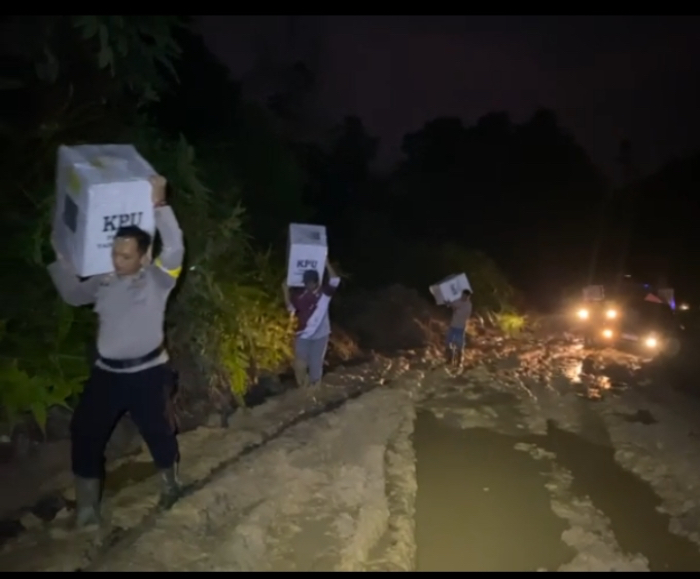 Sejumlah personil Polsek bersama Anggota PPK Rokan IV Koto memikul logistik pemilu dengan cara melansir di Desa Cipang Kiri Hulu, Kabupaten Rohul, Senin (12/2/2024).