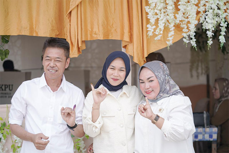 Bupati Rohil Afrizal Sintong bersama sang istri Sanimar dan sang putri Nalladia Ayu Rokan memperlihatkan jari kelingking tandai telah mengunakan hak suaranya di TPS 02 Kepenghuluan Sintong Bakti.