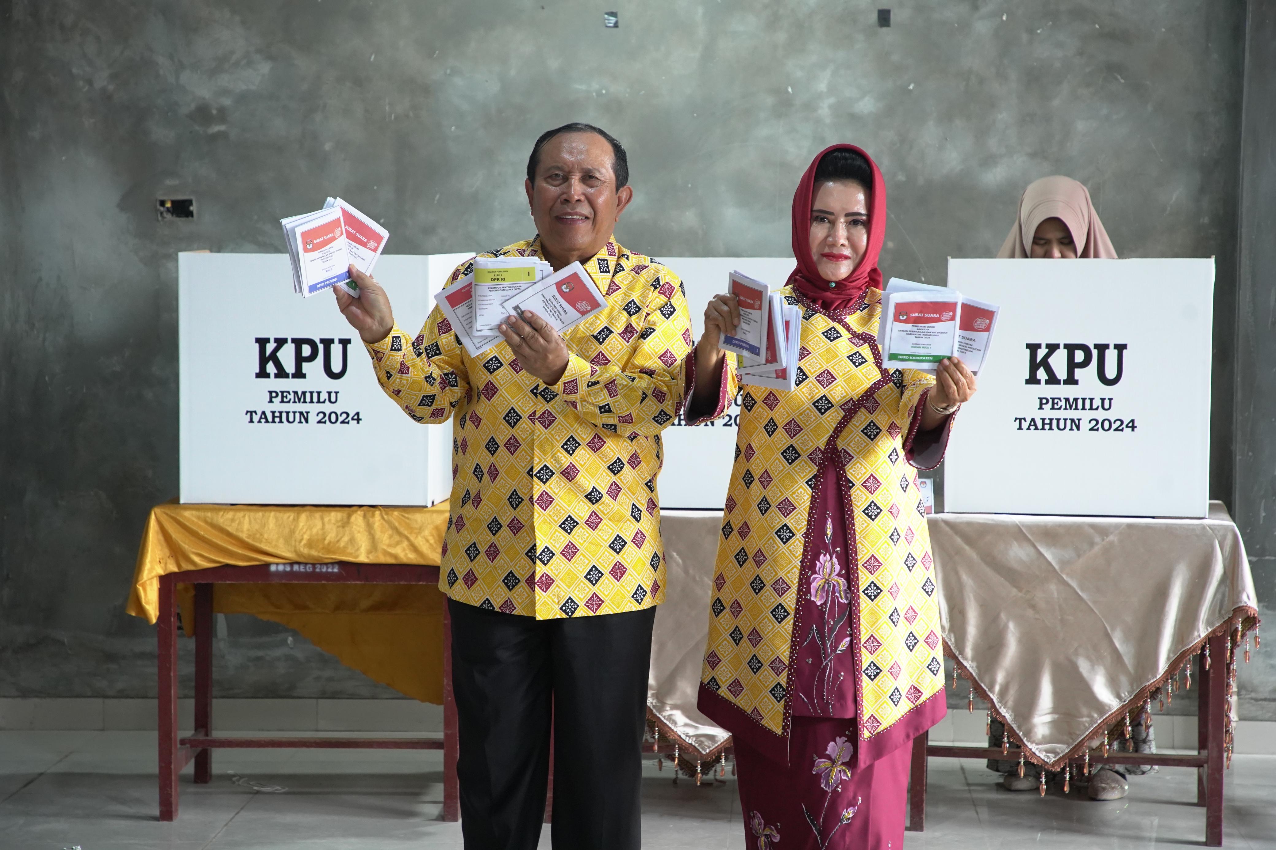 Bupati Rohul H Sukiman bersama Istri Hj Peni Herawati Sukiman menyalurkan hak pilihnya di TPS 20 Desa Pematang Berangan,Kecamatan Rambah, Rabu (14/1/2024).
