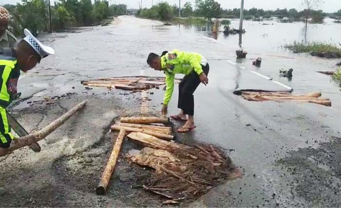 Petugas gabungan menutup lubang Jalan Lintas Timur Km 83 Desa Kemang, Kecamatan Pangkalan Kuras, Kabupaten Pelalawan yang rusak, Rabu (14/2/2024).