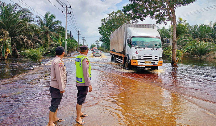 ATUR LALU LINTAS: Petugas gabungan mengatur lalu lintas di Jalan Lintas Timur Km 83 Desa Kemang, Kecamatan Pangkalan Kuras, Kabupaten Pelalawan, Rabu (14/2/2024).