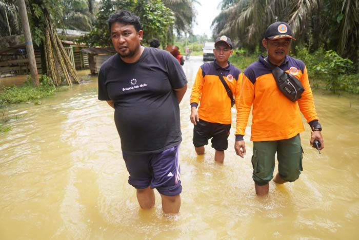 Sejumlah personel KPBD Inhu melakukan patroli jalan kaki di wilayah terdampak banjir, Senin (19/2/2024). Banjir terjadi akibat Sungai Cenaku meluap setelah wilayah daerah itu diguyur hujan.