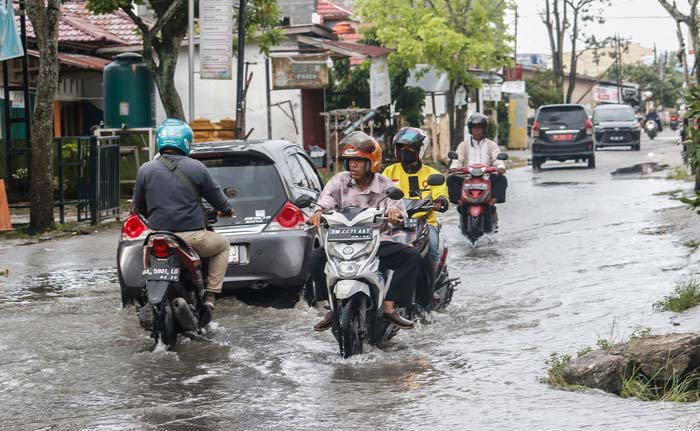 Pengendara kendaraan bermotor melewati genangan air di Jalan Garuda, Kecamatan Marpoyan Damai usai hujan deras mengguyur Kota Pekanbaru, Senin (19/2/2024).