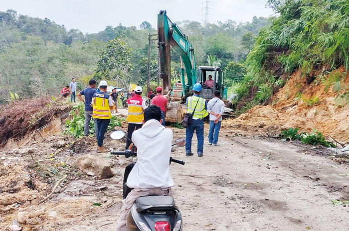 Petugas Balai Pelaksanaan Jalan Nasional Riau menggunakan alat berat saat membersihkan material longsor di Jalan Lintas Riau-Sumbar via Kiliran Jao, Desa Kasang, Kecamatan Kuantan Mudik, Kuansing