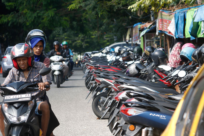 Pengendara melintas di Jalan Mustika, di mana satu lajur sisi kiri diberlakukan parkir kendaraan dan Dinas Perhubungan Pekanbaru memberlakukan rekayasa lalu lintas satu