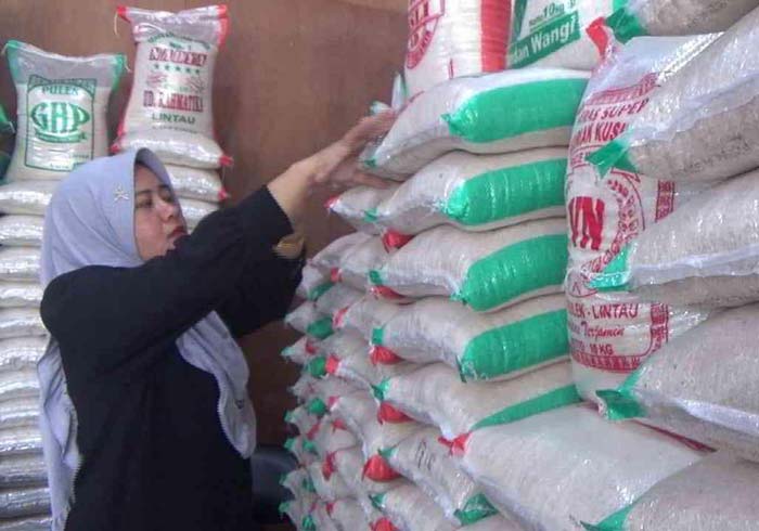 Pedagang menyusun beras yang dijual di toko beras Jalan Parit Indah, Pekanbaru, Kamis (22/2/2024).