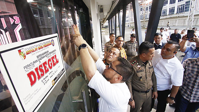 Petugas menyegel tempat hiburan malam Axelle Resto & KTV (dahulunya bernama Joker Poker-JP) di Kompleks Panam Center, Jalan HR Soebrantas, Kecamatan Binawidya, Senin (26