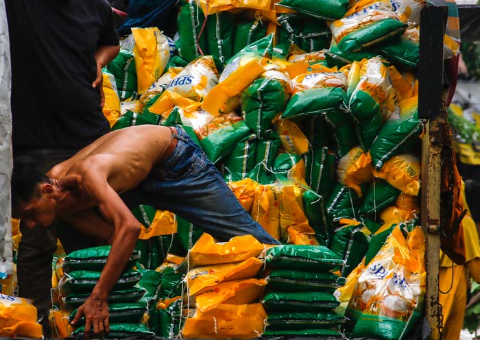 Pekerja buruh angkut menurunkan beras bulog atau beras SPHP dari truk di Pasar Cik Puan, Pekanbaru, Selasa (27/2/2024).