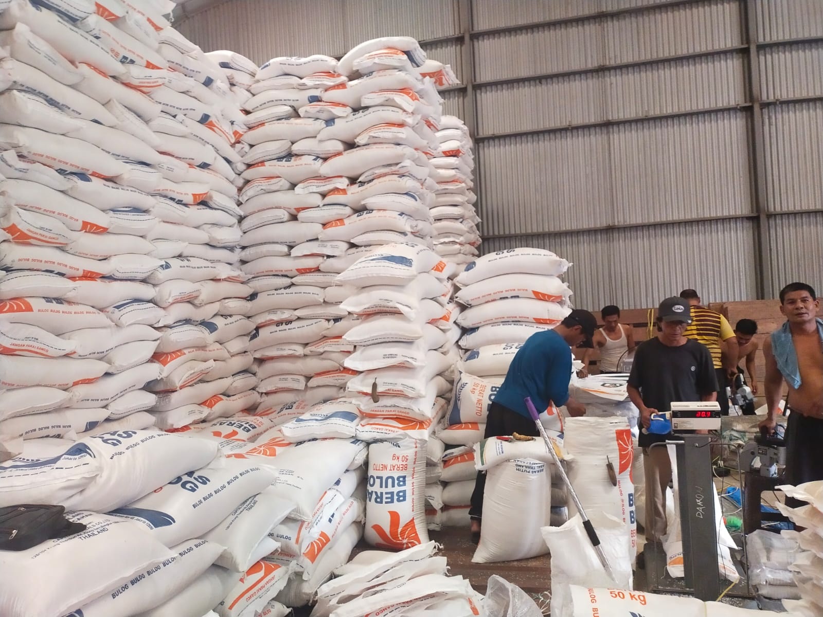 Petugas di Gudang Bulog Bengkalis memasukkan beras ke kemasan 5 kg untuk di pasarkan ke masyarakat, Selasa (27/2/2024).