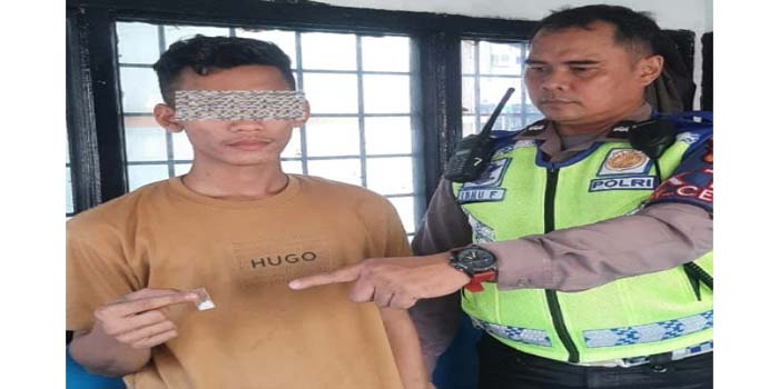 Personel Satlantas Polresta Pekanbaru menunjukkan barang bukti sabu yang dipegang SI (kiri) saat dia&shy;mankan di Pos Gurindam 9, Senin (26/2/2024).