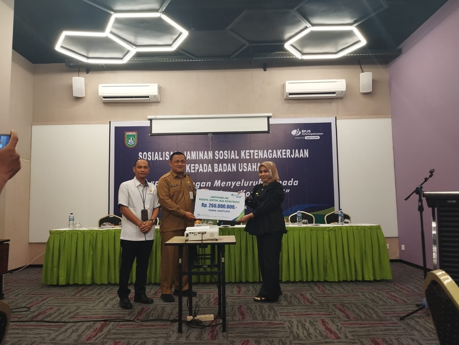 Kadisnaker Dumai Satrio Wibowo didampingi Kepala BP-Jamsostek Legi Handoko menyerahkan santunan kepada Astik, diwakilkan perwakilan perusahaan Andalas Metalcon Agung Selvi Rika, Kamis (29/2/2024).